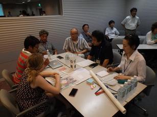 白いテーブルを囲んで意見交換をしている6人の男女の写真