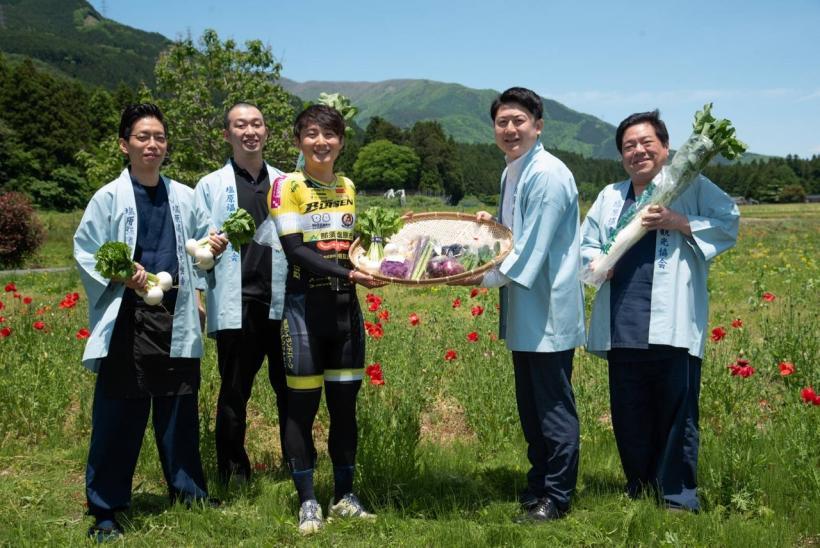 五人の男性が塩原温泉郷の土地で生産された野菜などの食物を持って立っている写真