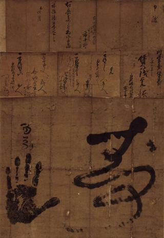茶色い紙に手形が押され、文字が書かれている菊地家市十郎百歳長寿祝文書の写真