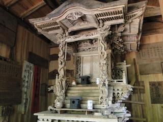屋内にある木造の三斗小屋温泉神社本殿の写真