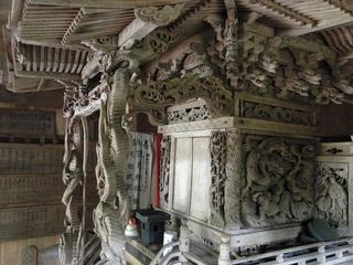 斜め前から木造の三斗小屋温泉神社本殿の細部を撮影した写真