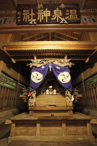 屋内にあり、木造で模様が入った布がかけられている板室温泉神社本殿の写真