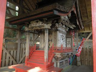 建物の中にある、赤い階段がついた木造の遙拝殿の写真