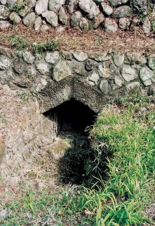 上が石で作られていて、下に穴がある那須疏水旧蛇尾川伏越出口の写真