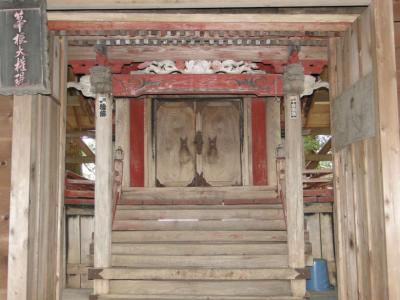 木の鳥居がありその奥に枠の部分が赤く塗られた本殿の扉が見えている上塩原箒根神社の写真