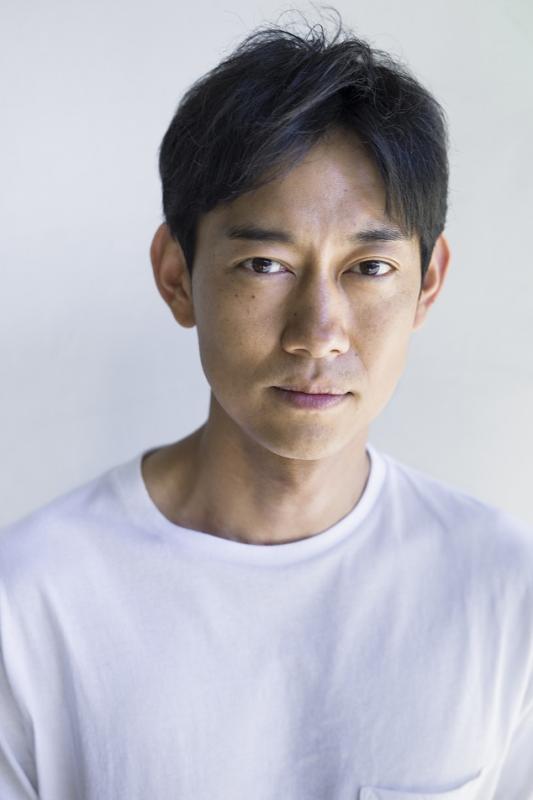 白いシャツを着て撮影された川岡大次郎さんの写真