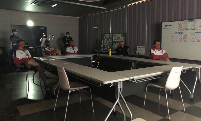 照明を落とした会議室で、プロジェクターから映し出された映像を鑑賞するオーストリア選手たちを、スクリーン側から撮影した写真