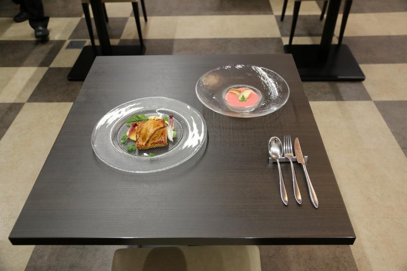 オーストリア選手たちに振る舞われた料理の写真。テーブルの上にはオニオンタシャールという肉と野菜のパイ包みと、甘酒のムースの2品が提供されているのが確認できる